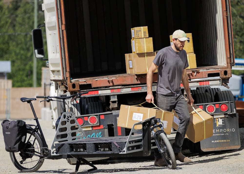 Jared Sartee moving boxes of bike parts from delivery truck